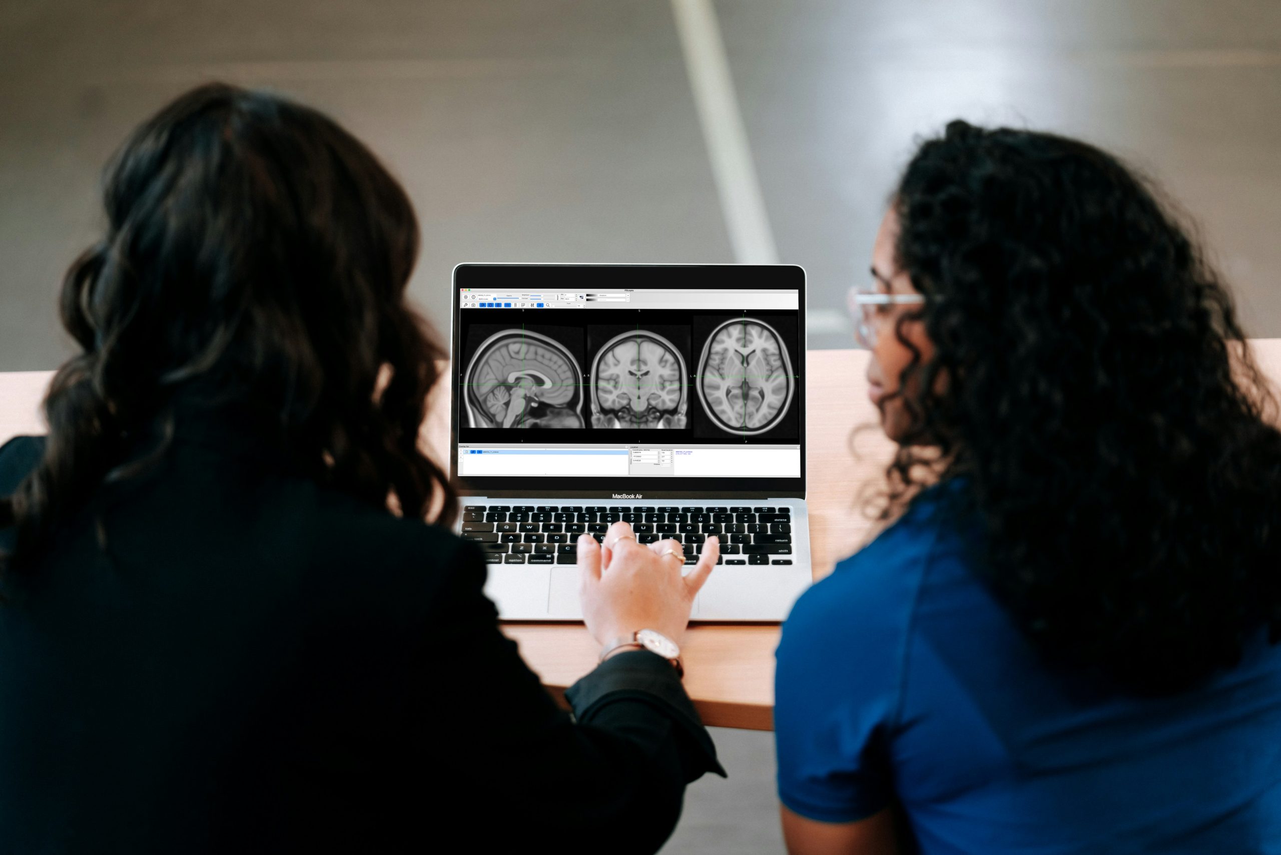 A provider and a patient discussing x-ray results shown on a computer.